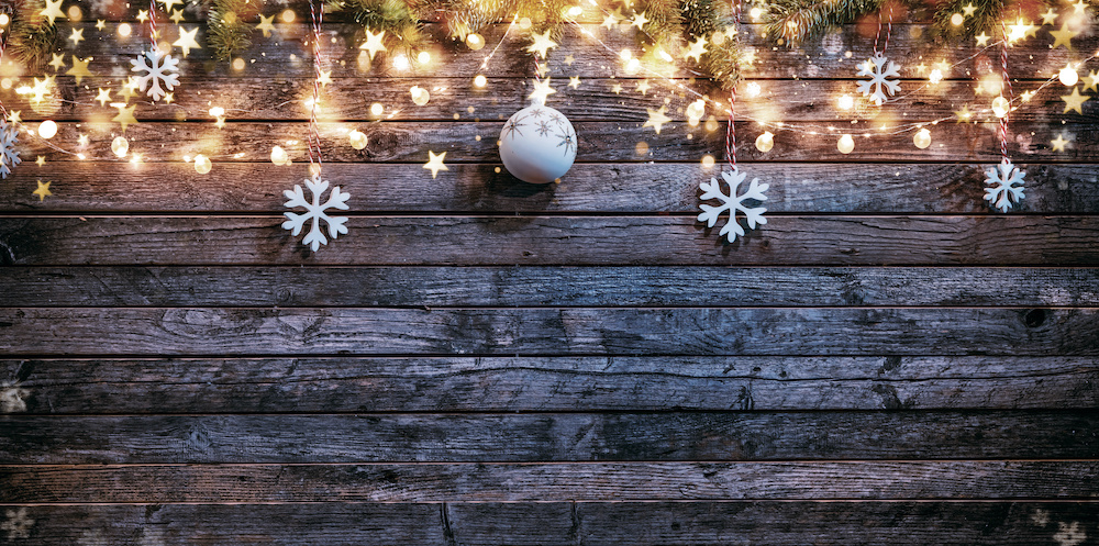 Holly and ornaments hanging down over wooden wall