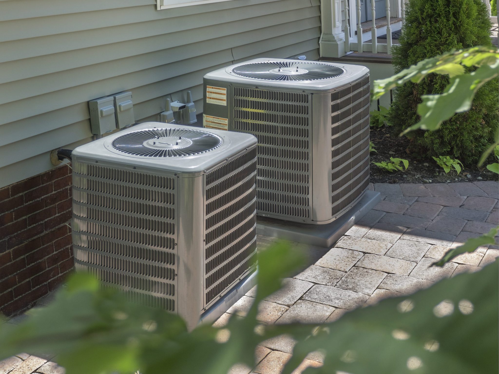 HVAC heating and air conditioning residential units side by side outside