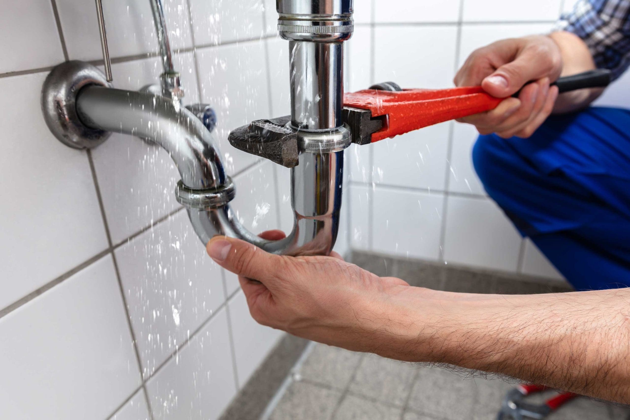 Plumber repairing sink with wrench