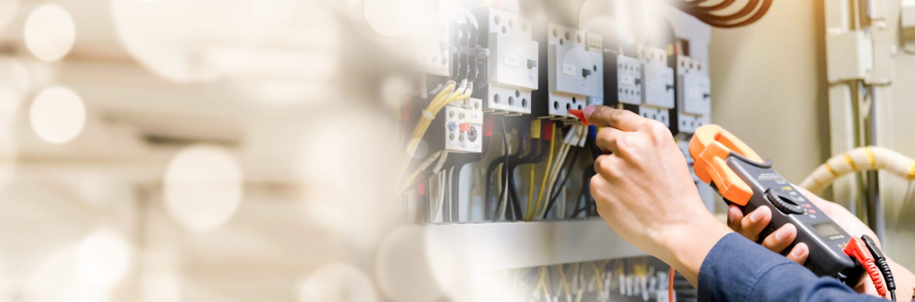 Electrician measuring output of an electric panel.