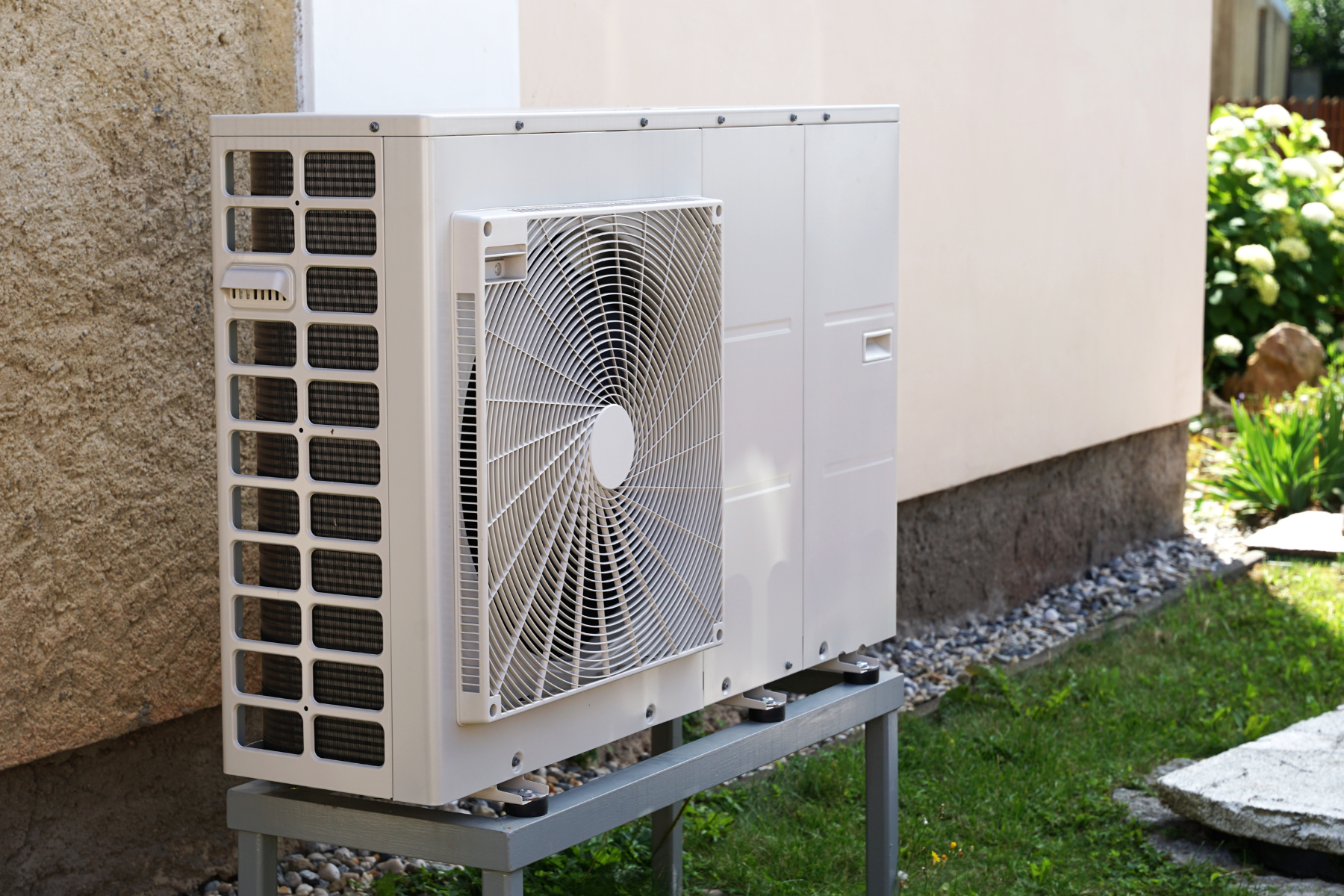 A modern outdoor air conditioning unit installed beside a house