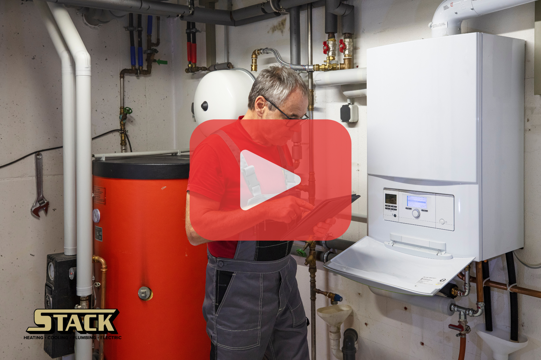 A technician inspecting a water heater system in a utility room, with a play button overlay.