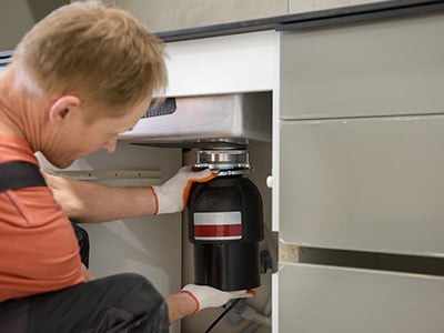 plumber installing a sink disposal