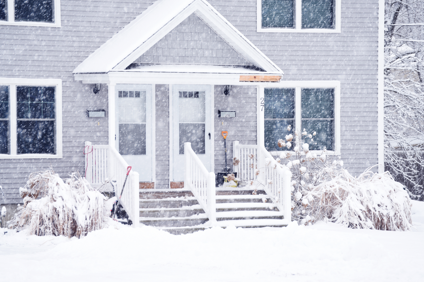 Grey house covered in snow.
