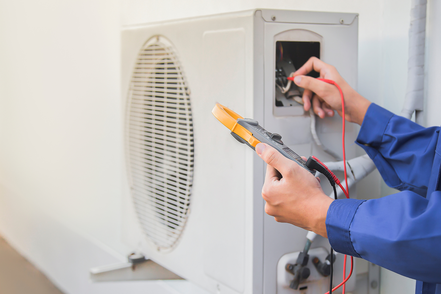 Person giving maintenance to AC unit.