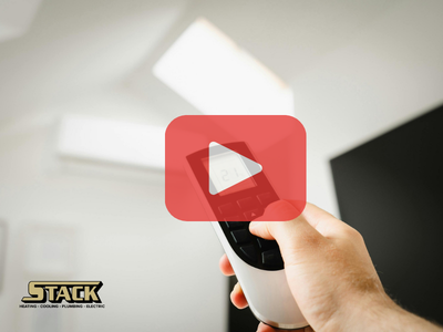 Person holding AC control remote pointing to AC. Red play buttom overlay and Stack logo.