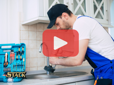 Man cleaning kitchen drain, Red play buttom overlay and Stack logo.