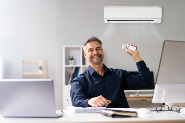 Person turning on AC in office space.