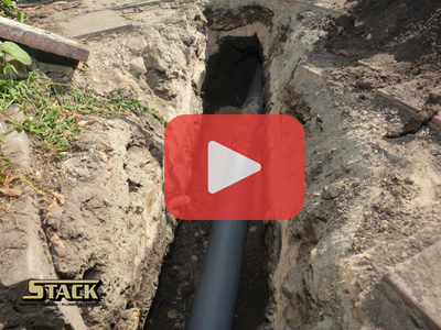 Top view of sewer line with red play buttom overlay and Stack logo.