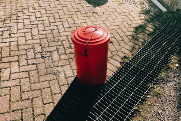 View of covered sewer line on paved yard.
