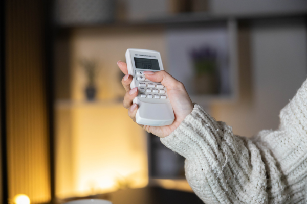 Woman using AC remote control.
