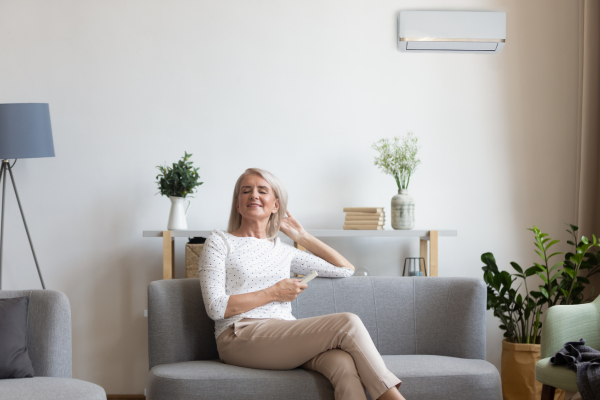 Elder woman sitting on couch in living room.