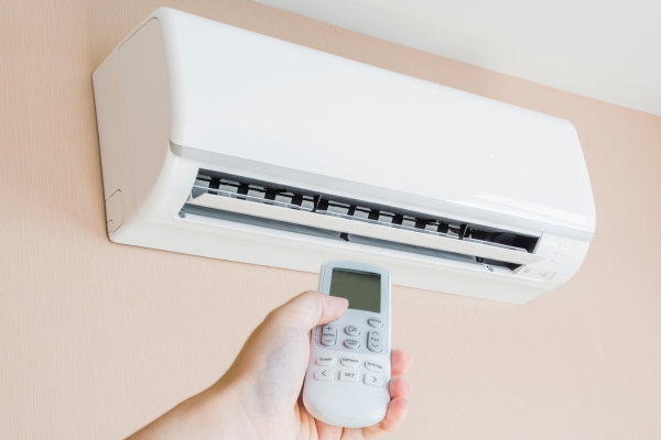 Person turning on AC unit with remote.