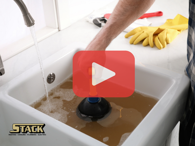 Person trying to unclog sink. Red play buttom overlay and Stack logo.
